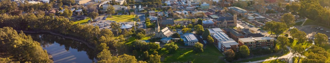Aerial view of Wagga Wagga, Australia, featuring a lake surrounded by lush greenery and the cityscape in the background